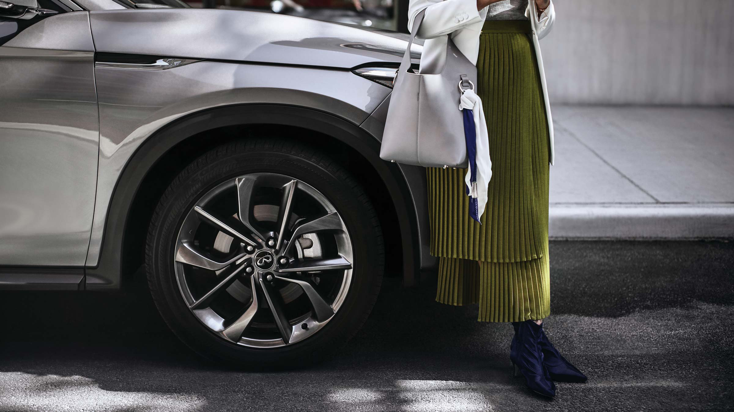 A woman standing next to her new 2022 INFINITI QX50 SUV.